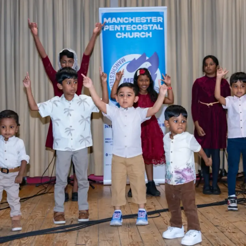 Children performing on stage at a Manchester Pentecostal Church event